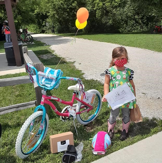 Two lucky scavenger hunt winners ride away on new bicycles